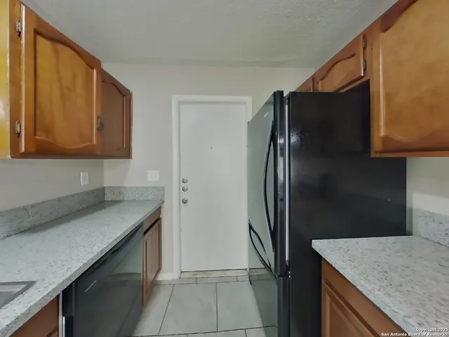 a kitchen with stainless steel appliances granite countertop a refrigerator and a sink