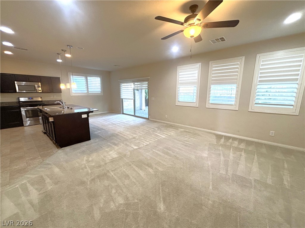 121 Elm Reed Avenue Las Vegas, NV 89113 - Photo 7 of 30 An open-concept living area features a modern kitchen island and direct outdoor access.