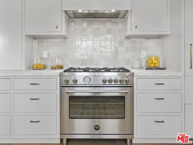 a stove top oven sitting inside of a kitchen