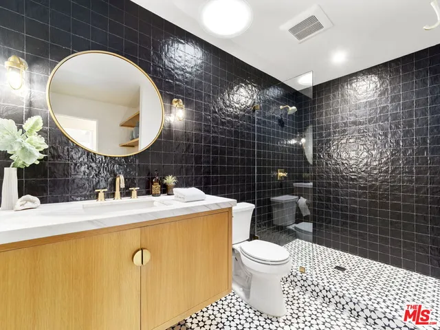 a bathroom with a sink mirror toilet and shower