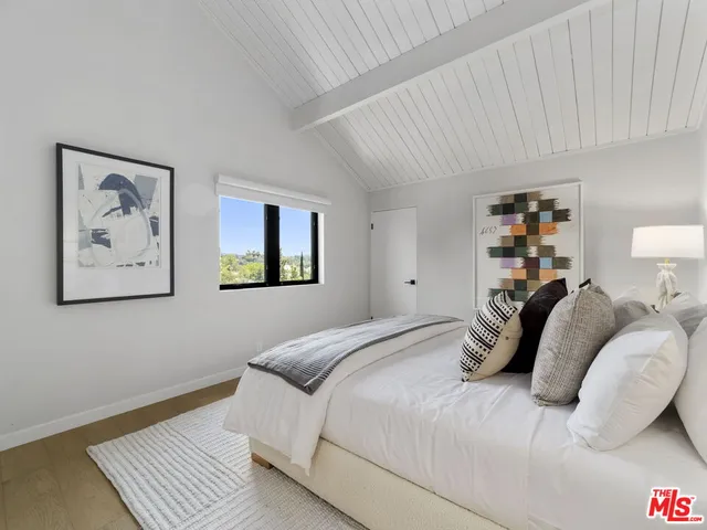 a bedroom with a bed and a painting on the wall