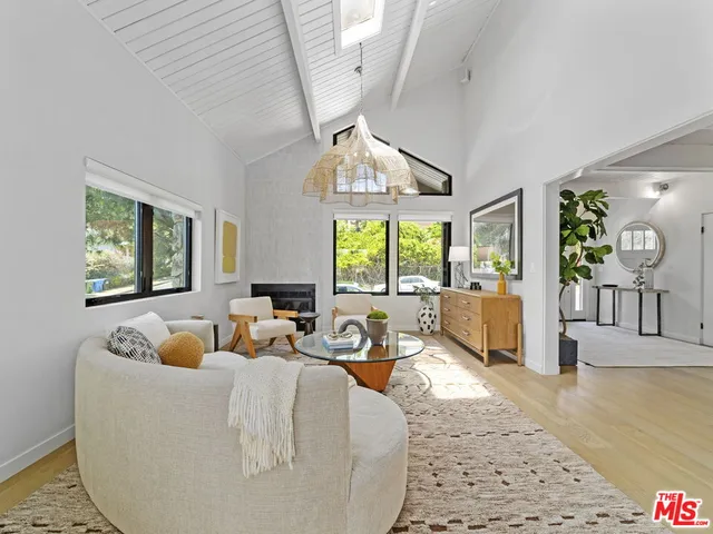 a living room with furniture fireplace and a large window