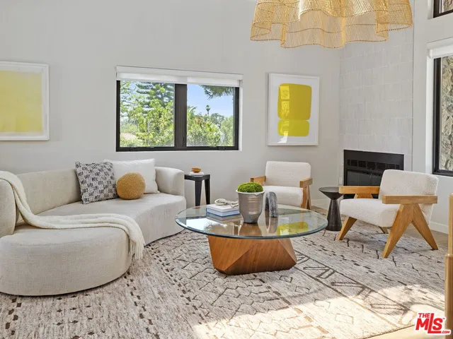 a living room with furniture a rug and a wall painting