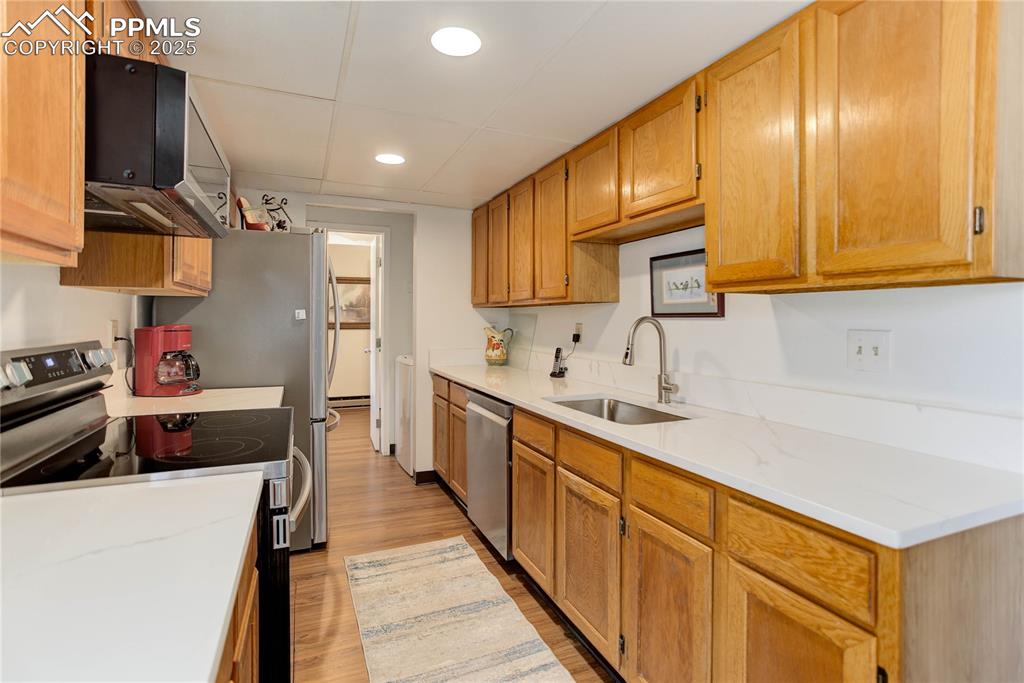 5102 Rainbow Harbour Circle Colorado Springs, CO 80917 - Photo 8 of 25 a kitchen with stainless steel appliances a sink stove and cabinets