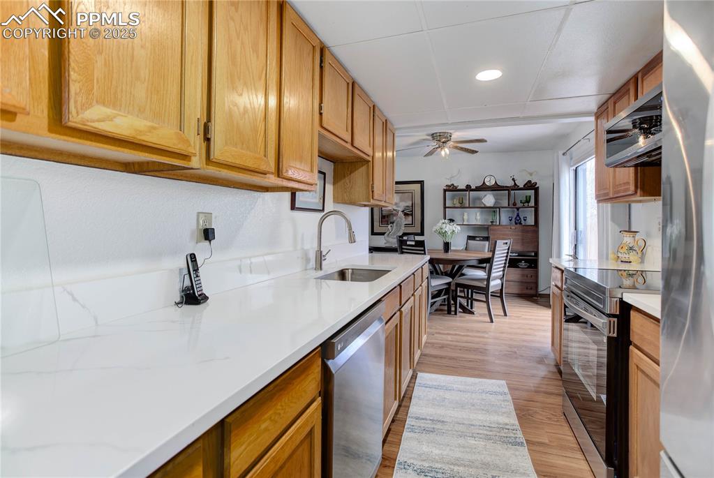 5102 Rainbow Harbour Circle Colorado Springs, CO 80917 - Photo 10 of 25 a kitchen with stainless steel appliances granite countertop a sink and cabinets