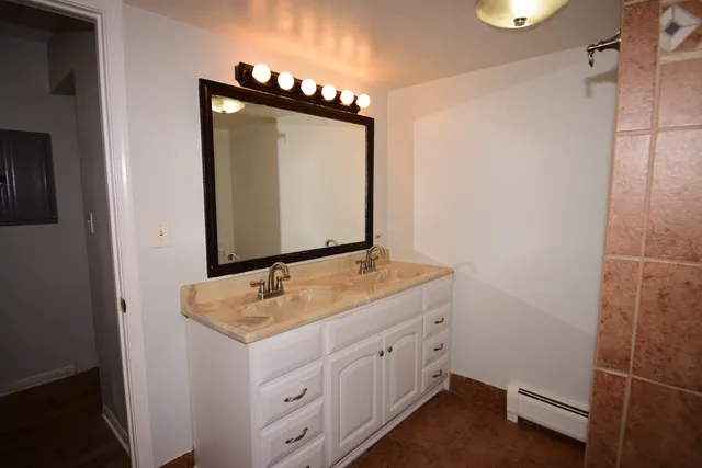 a bathroom with a granite countertop sink and a mirror