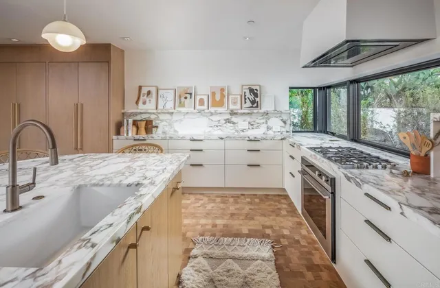 a large kitchen with stainless steel appliances granite countertop a stove a sink dishwasher and cabinets with wooden floor