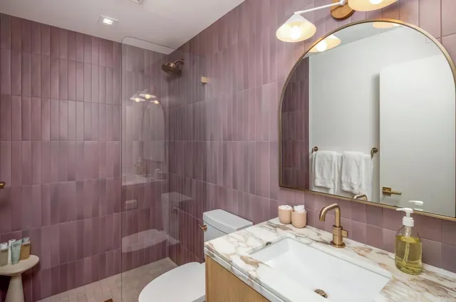 a bathroom with a sink a toilet and shower