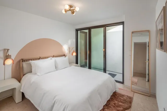 a bedroom with a large bed and a chandelier