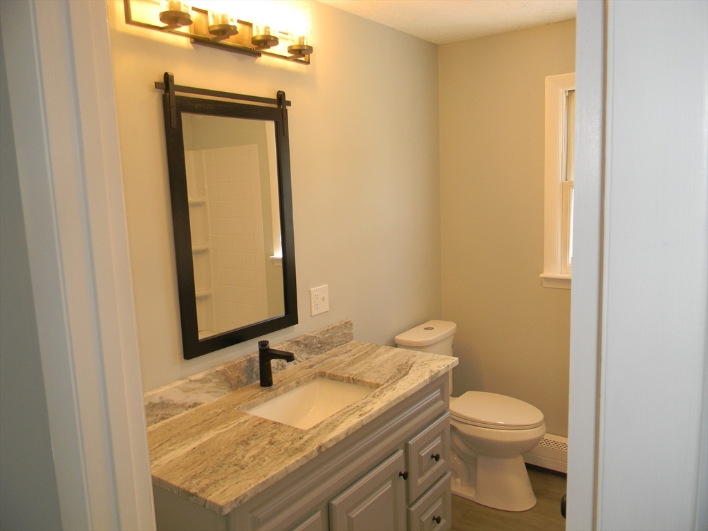 1 Lenox Street Athol, MA 01331 - Photo 16 of 37 a bathroom with a granite countertop toilet and mirror