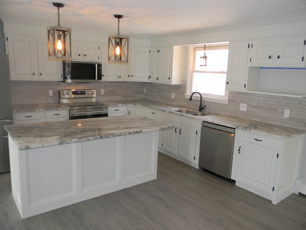 1 Lenox Street Athol, MA 01331 - Photo 4 of 37 a kitchen with granite countertop a sink stove and white cabinets