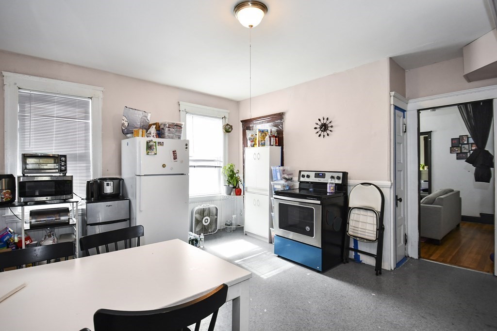 97 Arthur Street Worcester, MA 01604 - Photo 29 of 42 a kitchen with stainless steel appliances a stove a refrigerator a sink a dining table and chairs