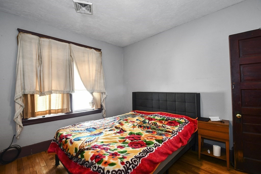 97 Arthur Street Worcester, MA 01604 - Photo 8 of 42 a bedroom with a bed and wooden floor