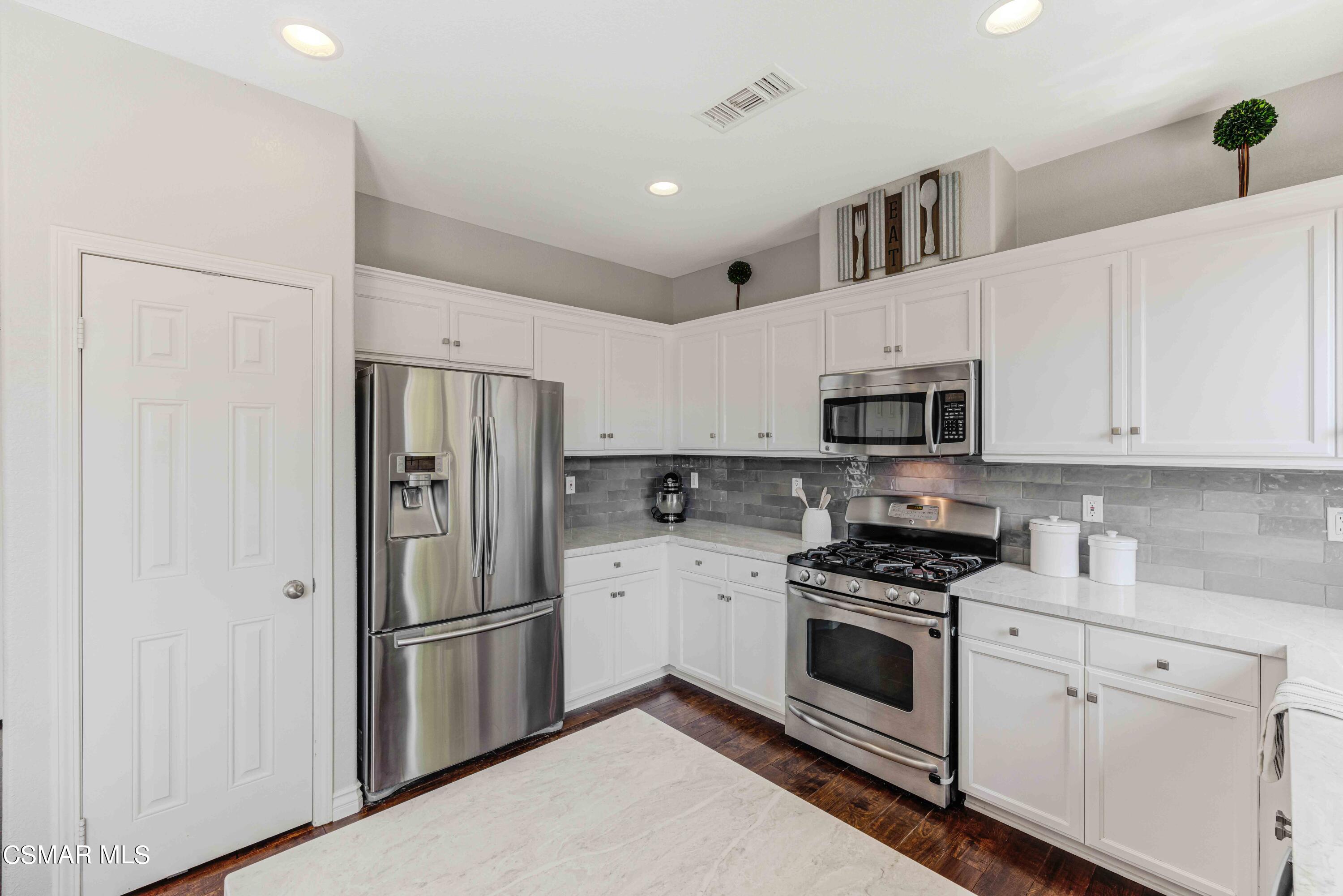 6802 Simmons Way Moorpark, CA 93021 - Photo 8 of 36 a kitchen with stainless steel appliances white cabinets and white appliances