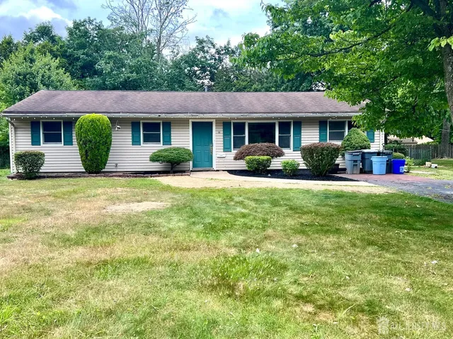 a view of a house with a yard and sitting area