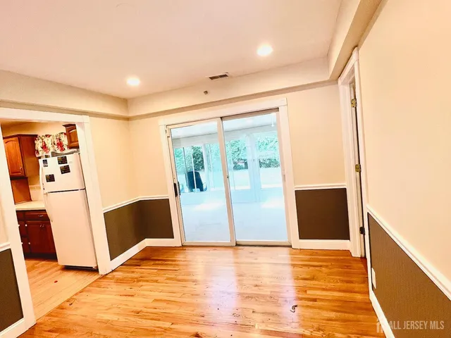 a view of a living room with wooden floor and a large window