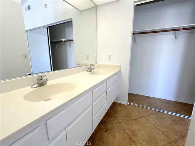 a spacious bathroom with a granite countertop sink and a mirror