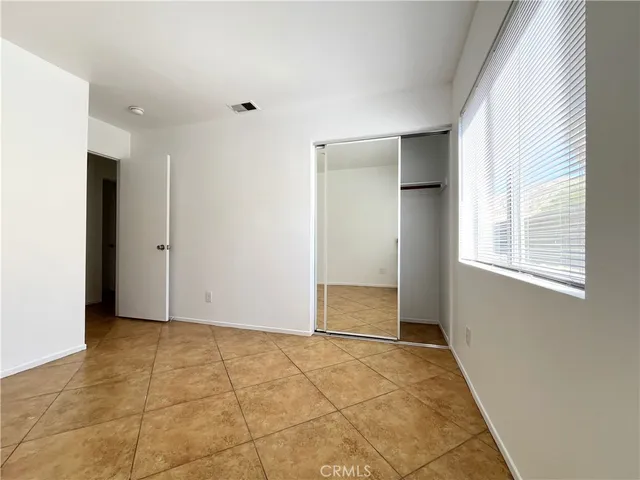 an empty room with windows and closet