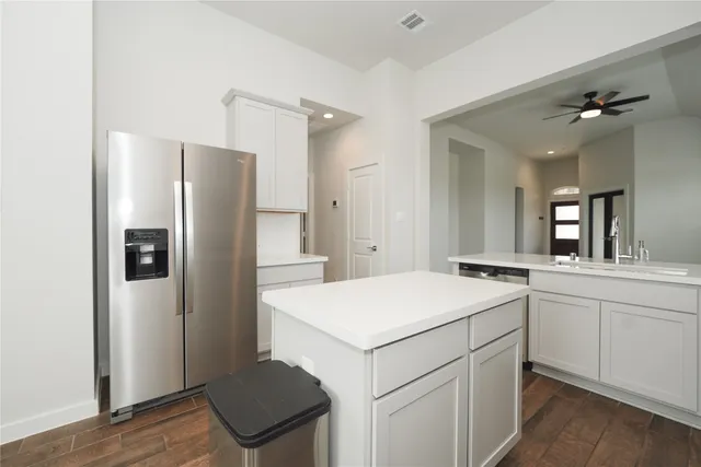 a kitchen with a refrigerator sink and cabinets
