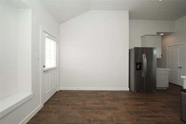 a view of a hallway with wooden floor and closet