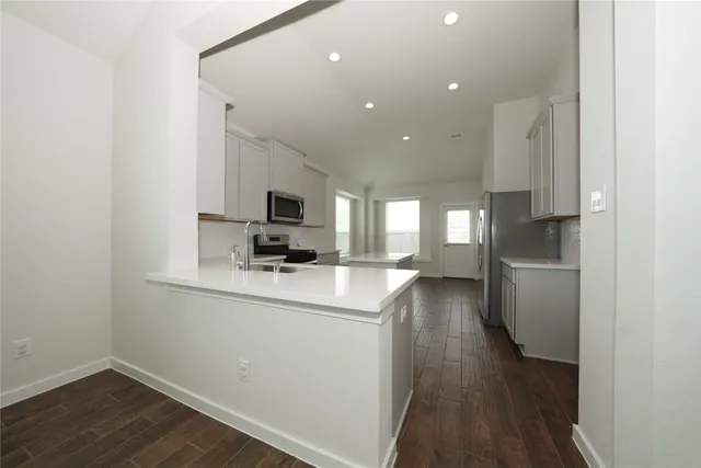 a kitchen with a refrigerator and a stove top oven