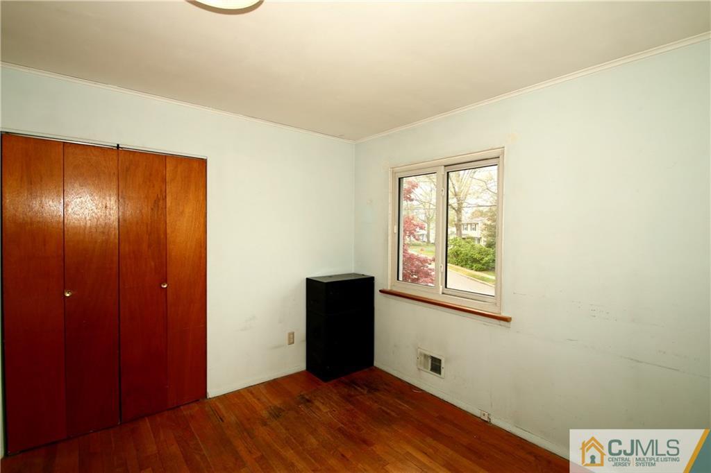 35 Rieder Road Spotswood, NJ 08884 - Photo 20 of 25 an empty room with wooden floor closet and windows