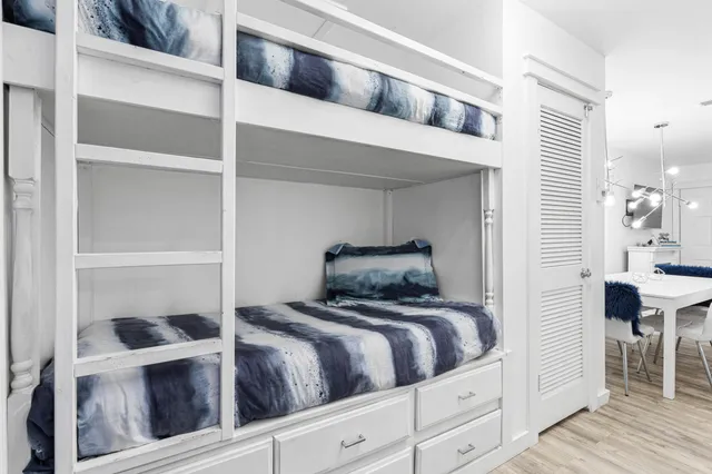 a kitchen with stainless steel appliances granite countertop a sink a stove a refrigerator and island with wooden floor