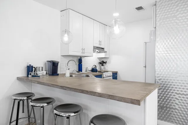 a kitchen with a sink a refrigerator and wooden floor
