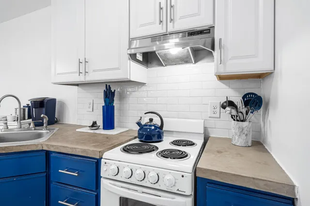 a living room with furniture a rug and white walls