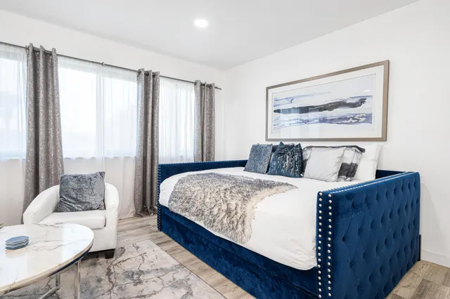 a bed sitting in a bedroom next to a window