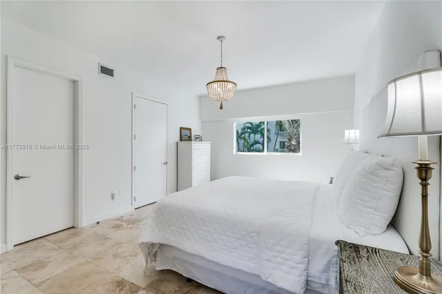 a bedroom with a bed and a chandelier