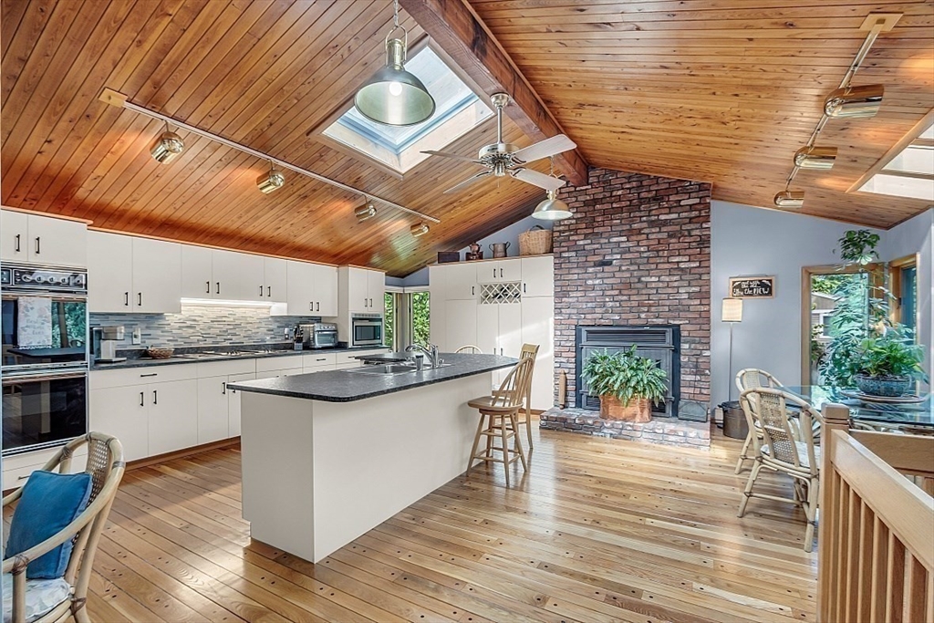 4 Belfast Road Peabody, MA 01960 - Photo 11 of 34 a kitchen with stainless steel appliances granite countertop a wooden floors and a fireplace