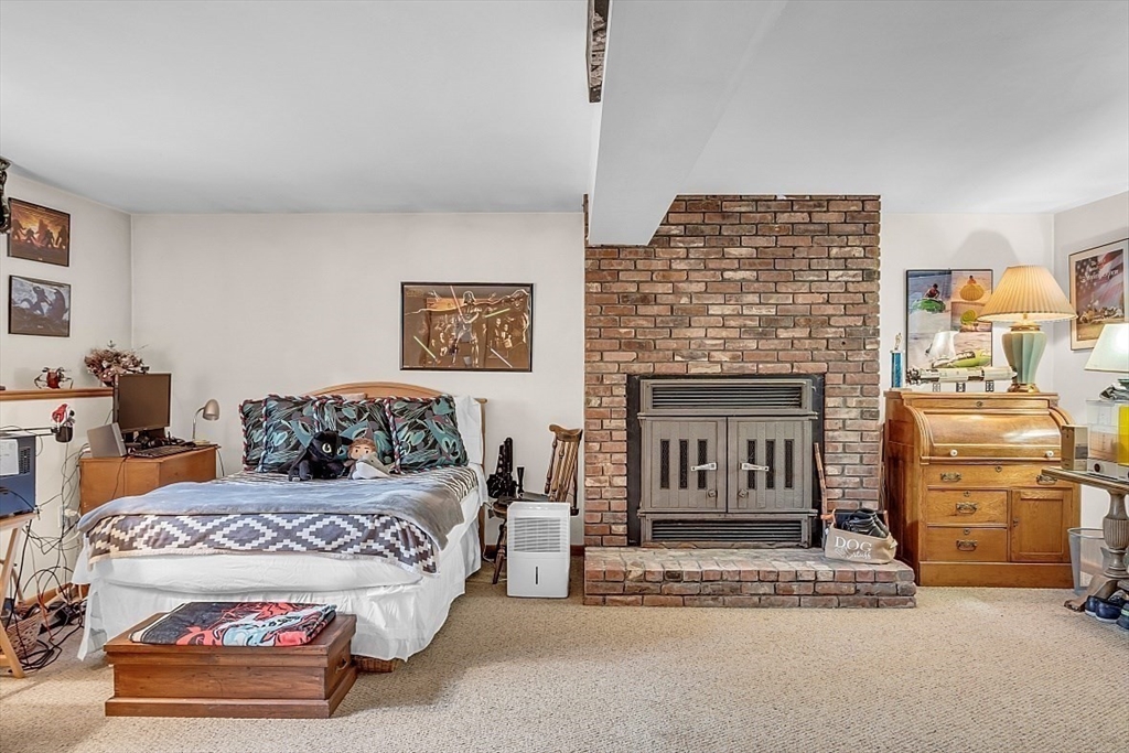 4 Belfast Road Peabody, MA 01960 - Photo 27 of 34 a bedroom with a bed and a fireplace