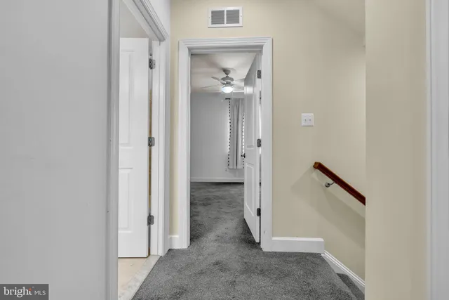 an empty room with a window and ceiling fan