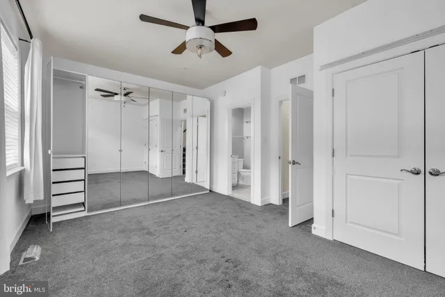 a view of a white house with a small yard and wooden fence