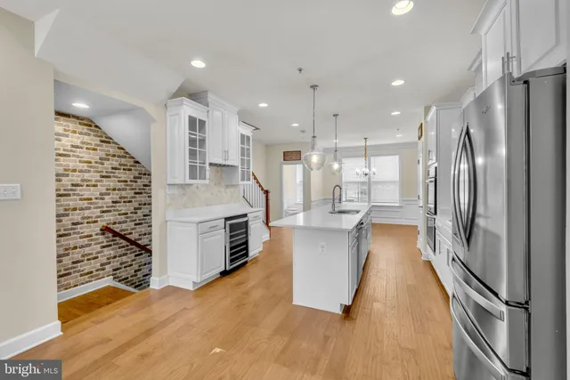 a large kitchen with stainless steel appliances a refrigerator and a stove top oven