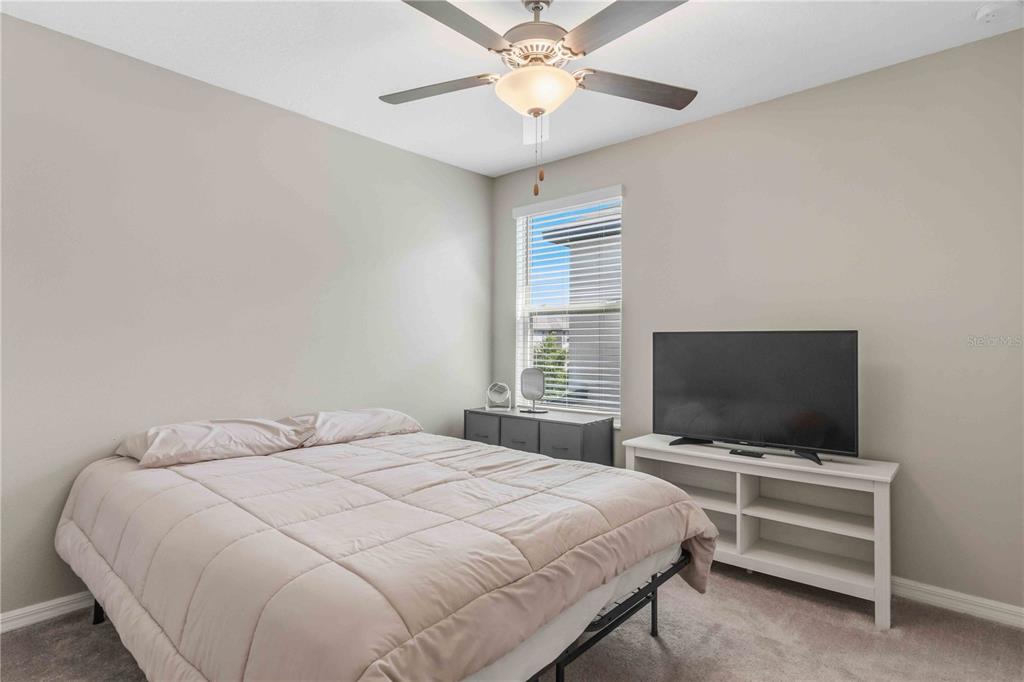 9440 Lemon Drop Loop Sun City Center, FL 33573 - Photo 38 of 55 a bedroom with a bed and a flat screen tv