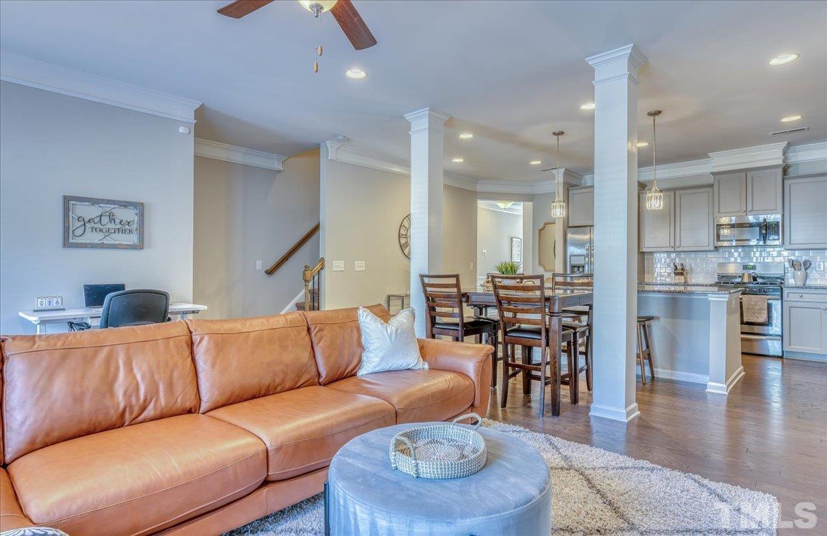 6328 Grace Lily Drive Raleigh, NC 27607 - Photo 11 of 27 a living room with furniture kitchen view and a wooden floor