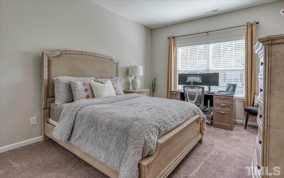 6328 Grace Lily Drive Raleigh, NC 27607 - Photo 14 of 27 a spacious bedroom with a bed and glass door