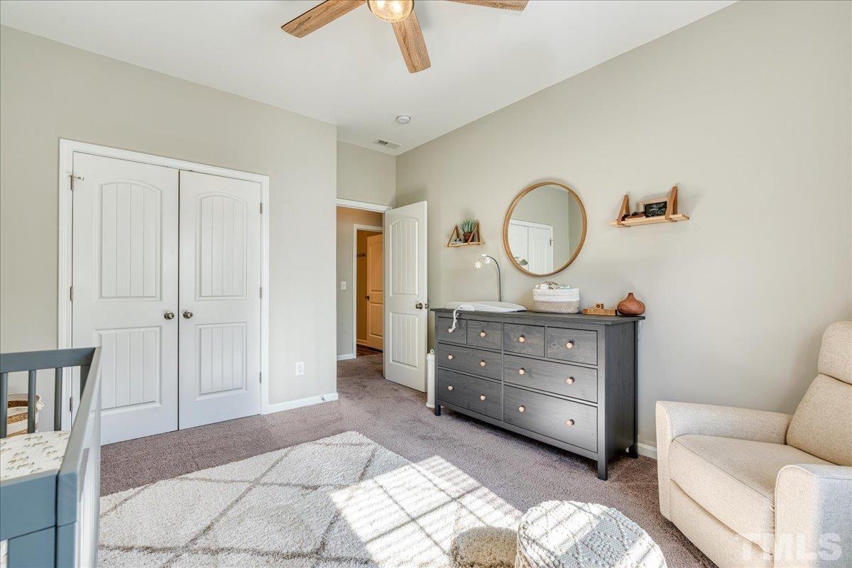 6328 Grace Lily Drive Raleigh, NC 27607 - Photo 17 of 27 a bedroom with a bed and a dresser