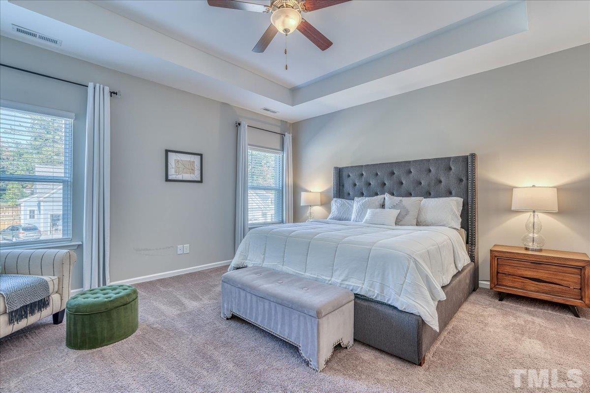 6328 Grace Lily Drive Raleigh, NC 27607 - Photo 19 of 27 a spacious bedroom with a bed and a chandelier