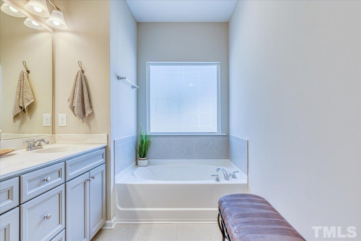 6328 Grace Lily Drive Raleigh, NC 27607 - Photo 20 of 27 a bathroom with a tub sink and mirror