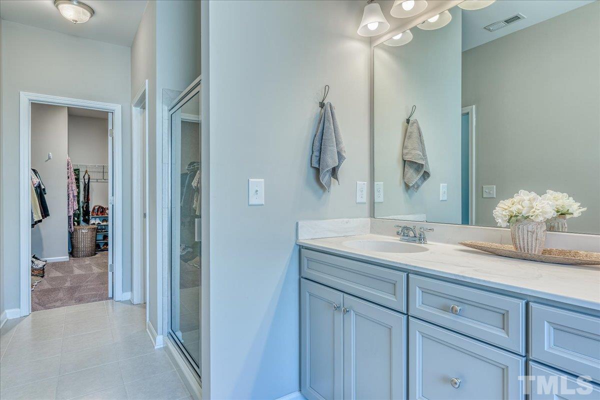 6328 Grace Lily Drive Raleigh, NC 27607 - Photo 22 of 27 a en suite bathroom with double sink and a mirror