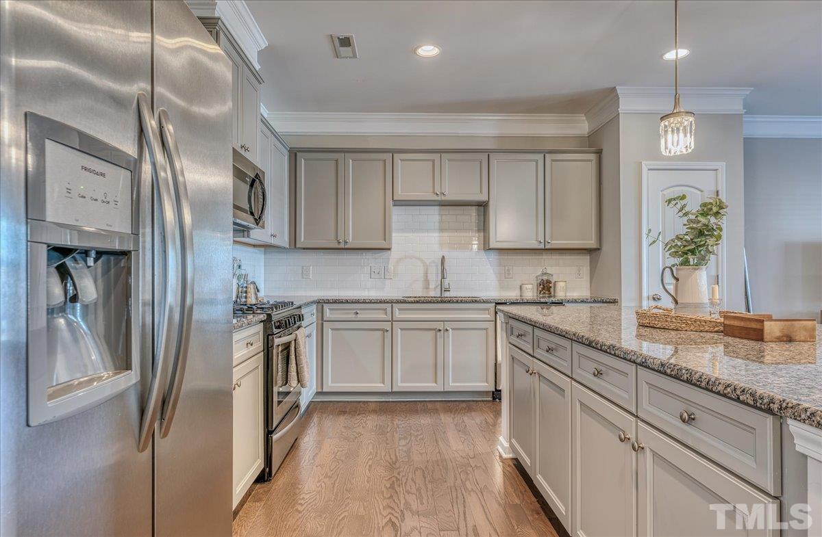 6328 Grace Lily Drive Raleigh, NC 27607 - Photo 6 of 27 a kitchen with stainless steel appliances granite countertop a sink a stove and a refrigerator