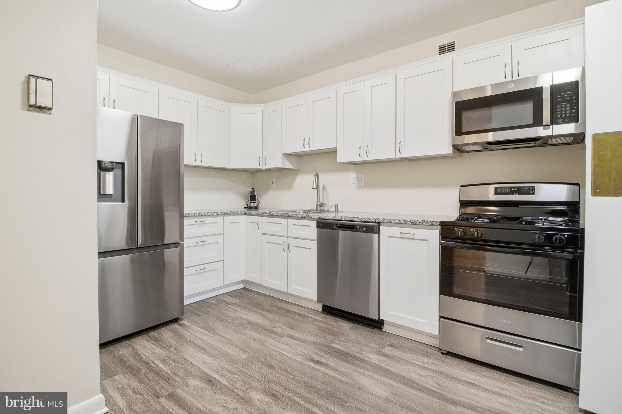 4100 Cathedral Avenue Northwest, Unit 818 Washington, DC 20016 - Photo 2 of 15 a kitchen with stainless steel appliances a refrigerator stove and microwave