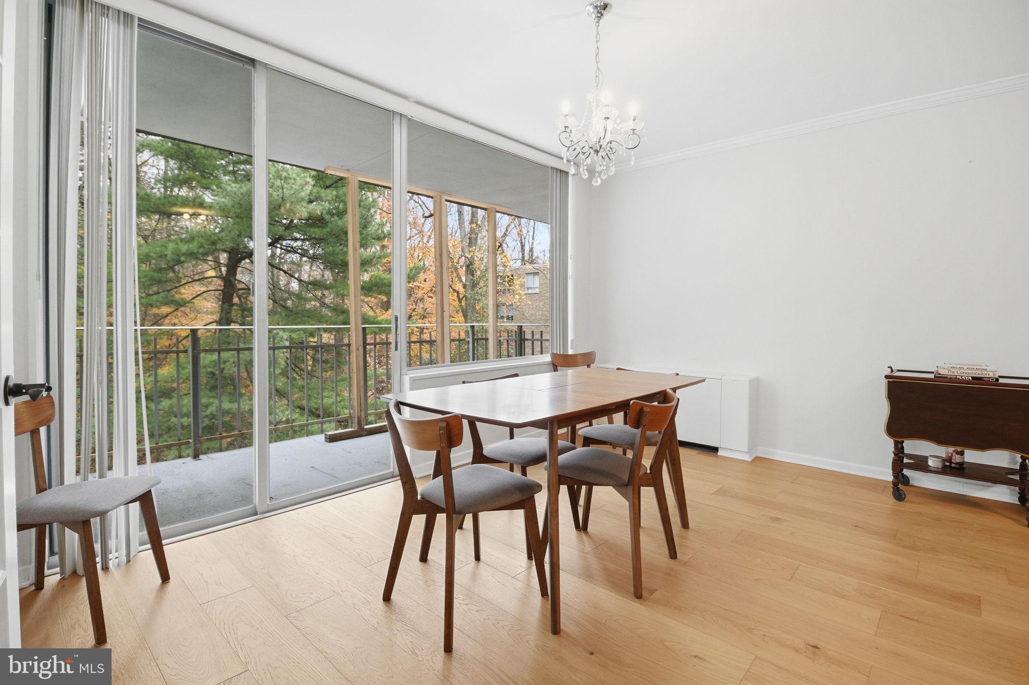 4100 Cathedral Avenue Northwest, Unit 818 Washington, DC 20016 - Photo 4 of 15 a dining room with furniture a chandelier and wooden floor