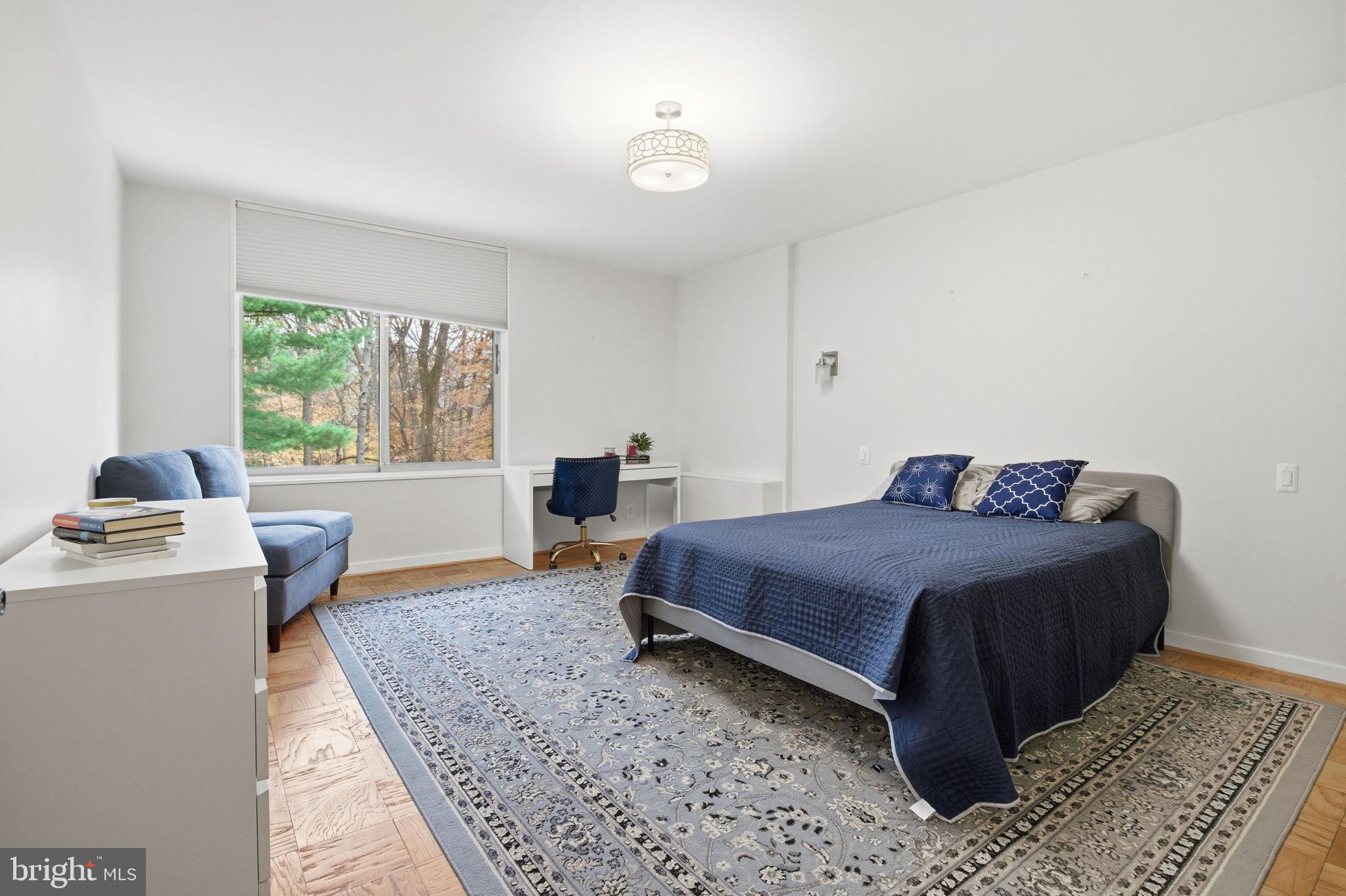 4100 Cathedral Avenue Northwest, Unit 818 Washington, DC 20016 - Photo 6 of 15 a bedroom with a bed and a table in it