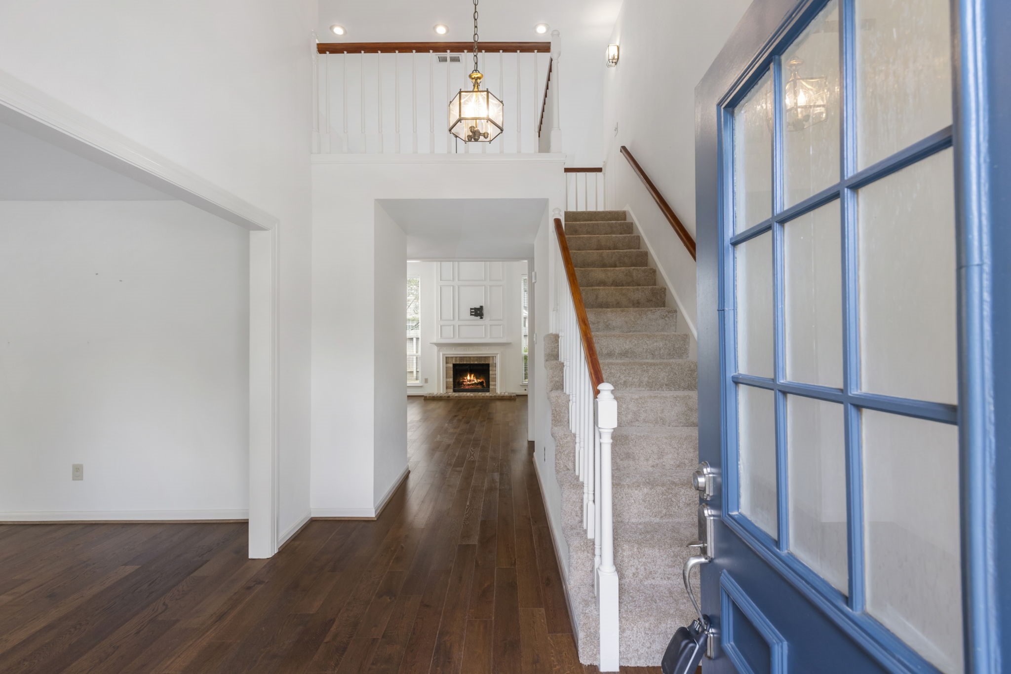 59 Fire Flicker Place Spring, TX 77381 - Photo 3 of 37 Step into an inviting entryway with soaring ceilings, leading to a bright and spacious interior adorned with elegant hardwood floors.