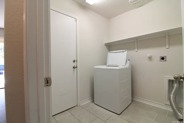 a utility room with cabinets washer and dryer