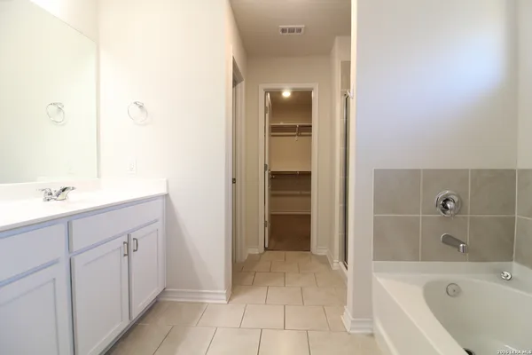 a spacious bathroom with a bathtub sink and mirror